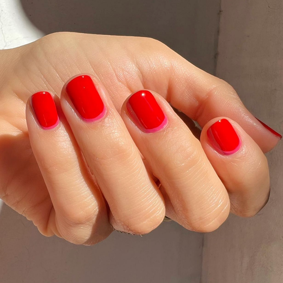 short red nails with a thin pink line near the cuticle 
