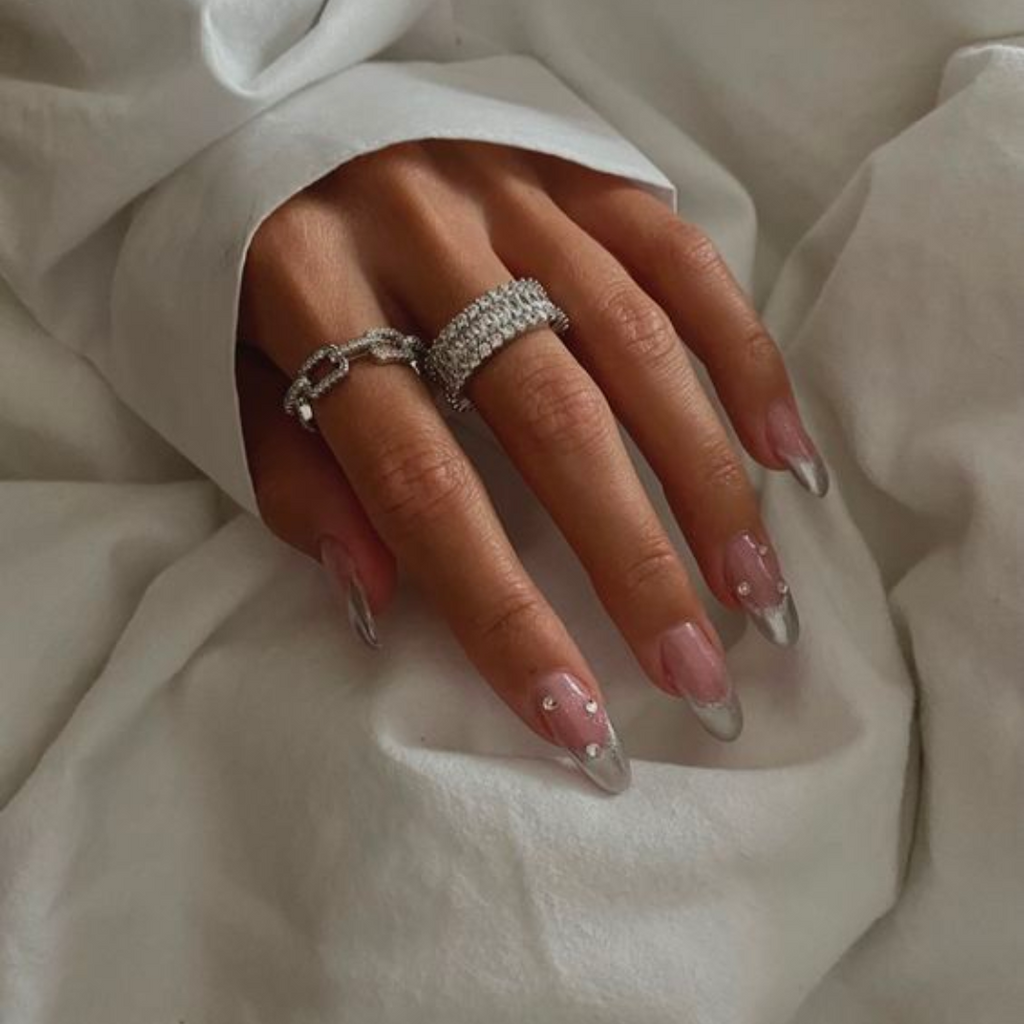 long almond nails with silver chrome french tips and scattered embellishments