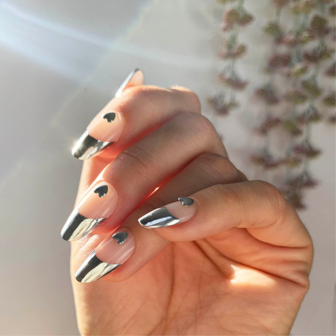 chrome french tip manicure with chrome hearts at base of nail