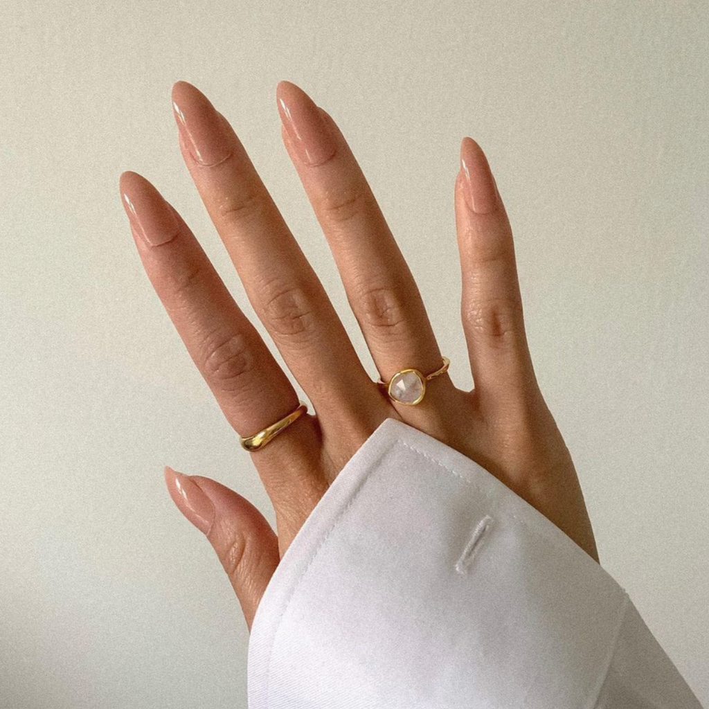 neutral almond shaped nails with gold rings