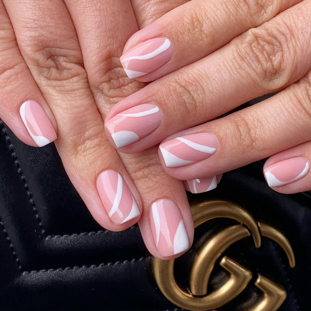 White swirl nail design on light pink base on short square nails