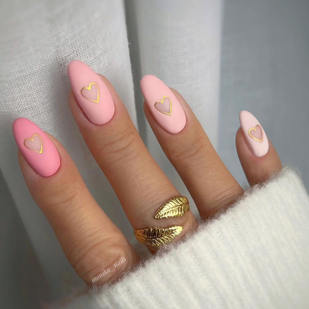 gradient pink almond nails with cut out hearts outlined in gold