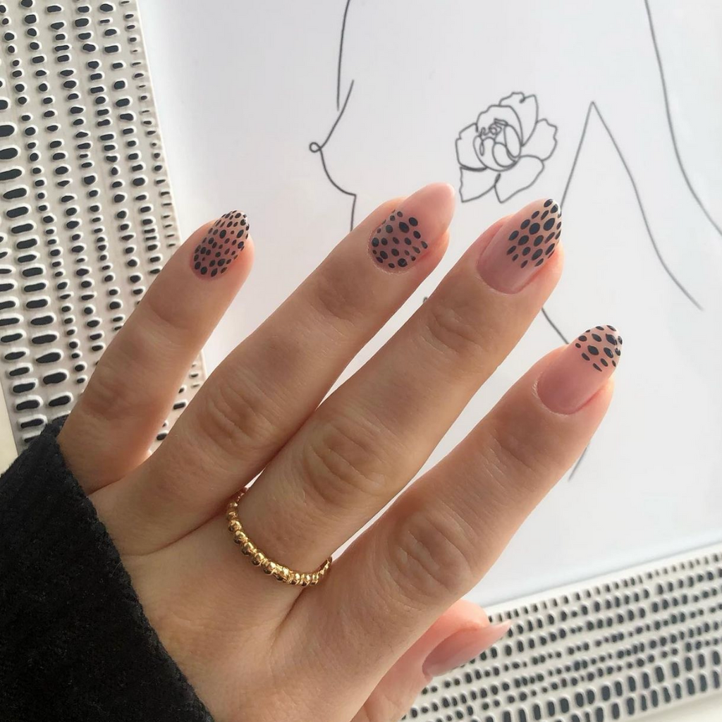 black graphic print on neutral almond shaped nails 