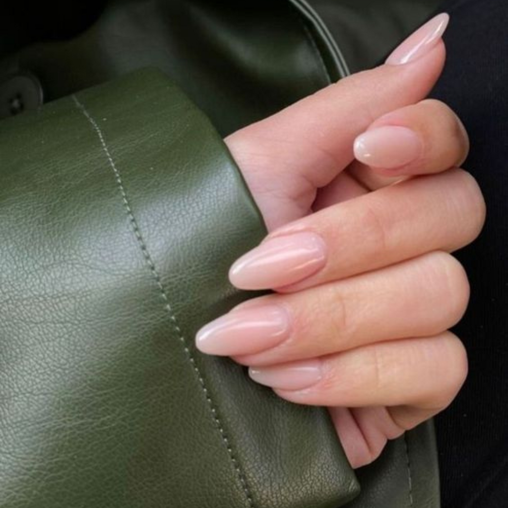 light pink medium oval nails holding green leather jacket sleeve 
