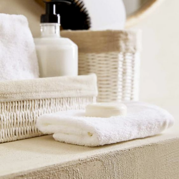 white face towel with a bar of soap on top in bathroom