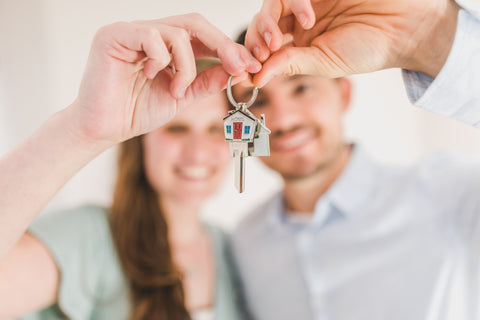 First time buyers holding up keys to their home
