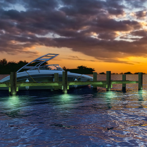 Boat docked along a wooden dock with SHOUL dock lights mounted underwater on the dock pillars