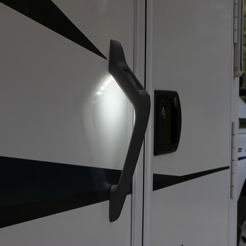 Black Attune Solar Powered LED handle lit up at night on the side of a travel trailer | ITC Shop Now