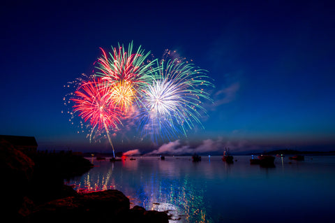 Fireworks over the lake with boats in the foreground