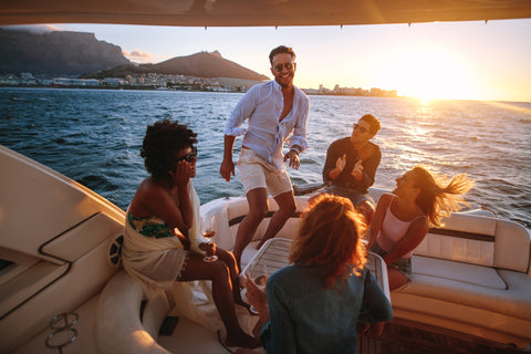 Friends dancing on a boat at sunset | ITC Shop Now