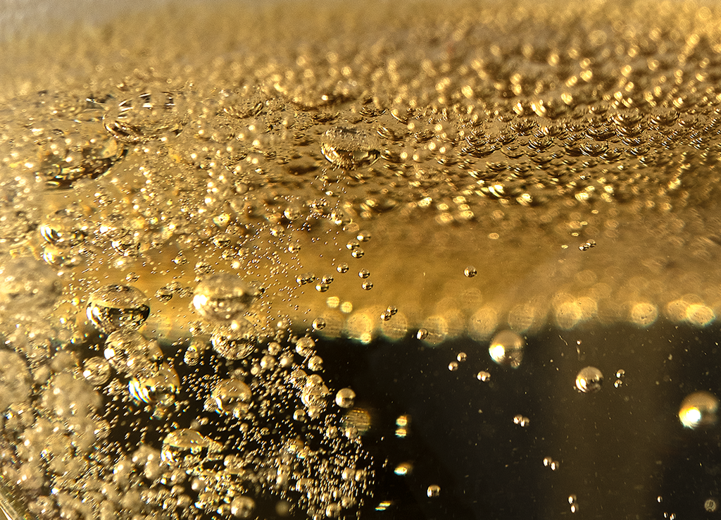 Closeup image of bubbles in glass of Champagne.