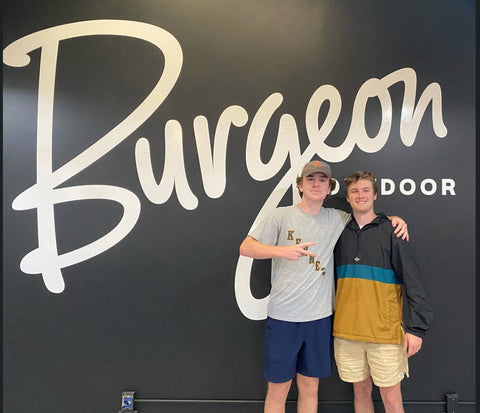 Tyler in front of the Burgeon Logo