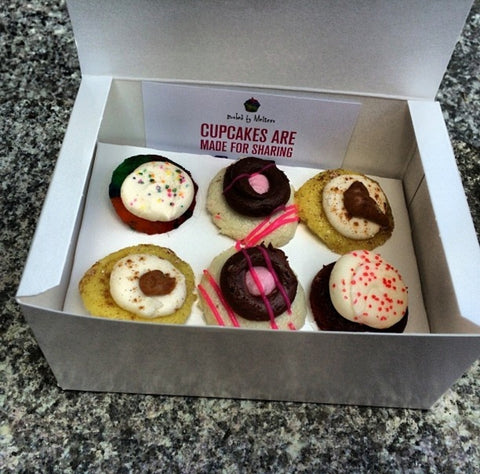 A box of Baked By Melissa cupcakes.