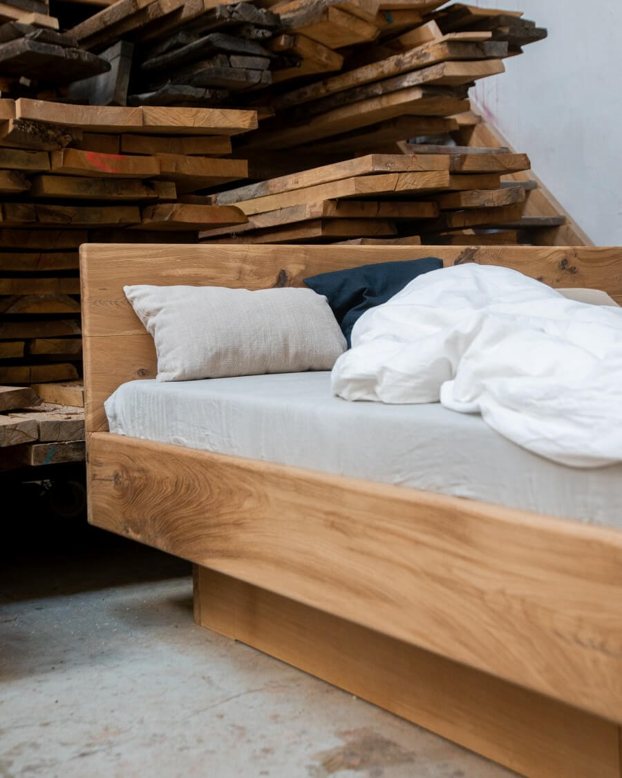 Un letto in legno massiccio davanti a assi di legno massiccio
