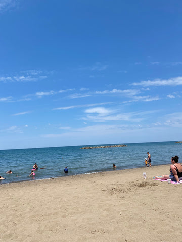 beach 6 at Presque Isle with blue sky and people in the lake water