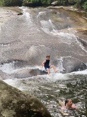 young boy plunging into mountain stream at Sliding Rock natural waterslide
