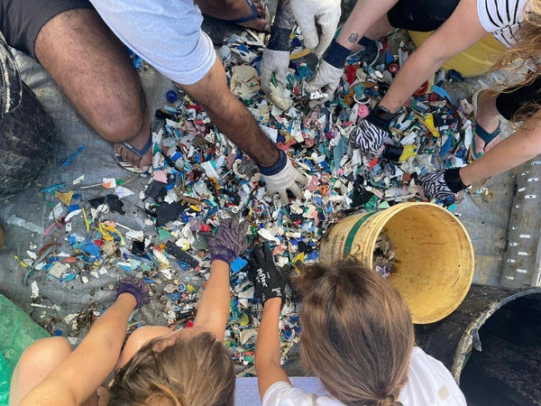 Plastic waste from the ocean being sorted by hand