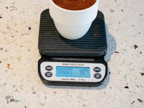 Gemalen koffie afmeten op een weegschaal voor de juiste dosering