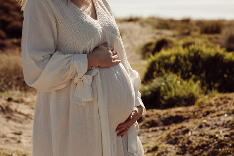 Pregnant women wearing an off white maternity dress