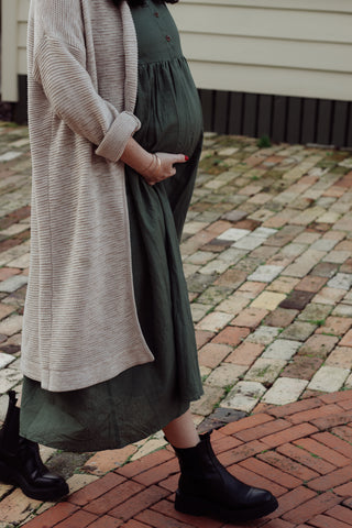 Green maternity dress layered with a cardigan 
