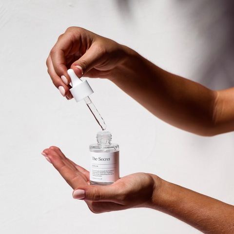 Person applying Serum from The Secret using the pipette applicator as part of their skincare routine.