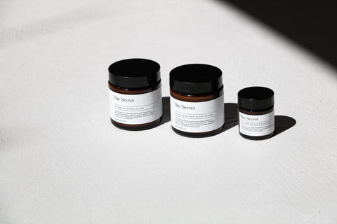 Products from The Secret's Skincare range on a white bench.