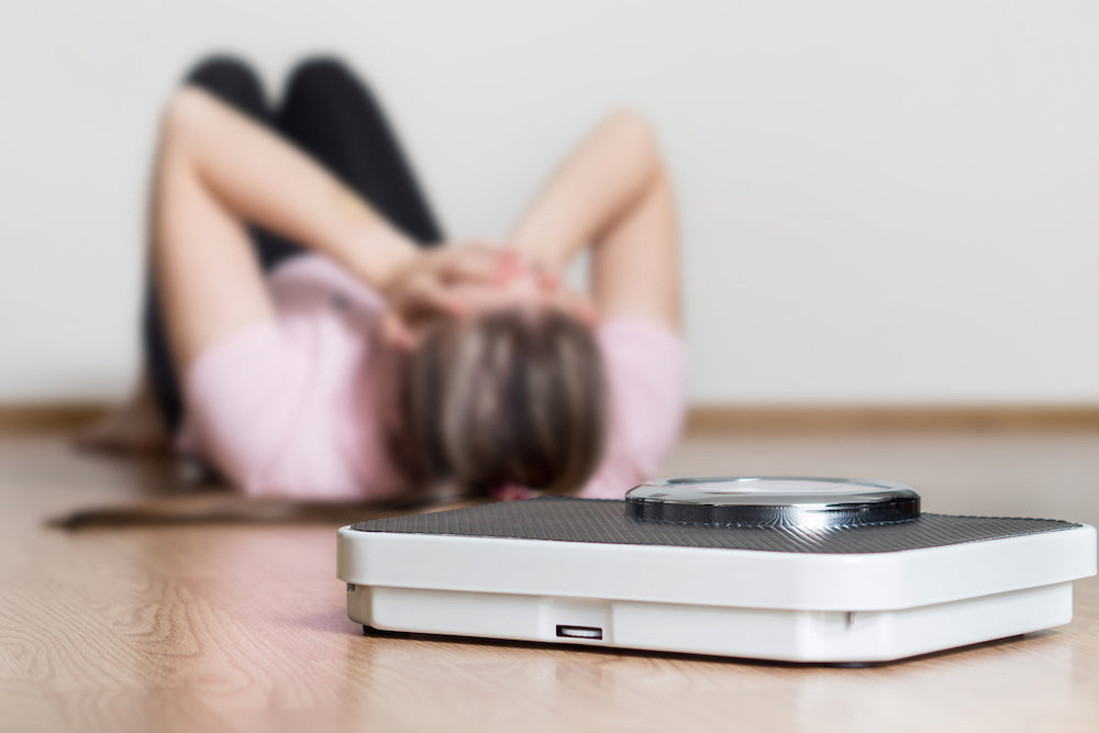 Woman lying next to scales