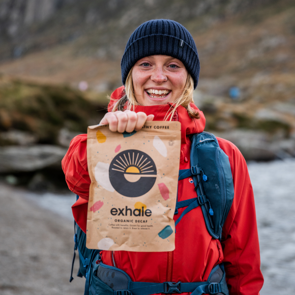 Exhale Healthy Coffee - Decaf being held by a girl in a red jacket