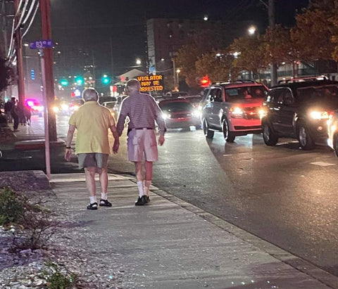 an older couple walks down the street during h2o ocean city md 2020 with the violators may be arrested sign in the background