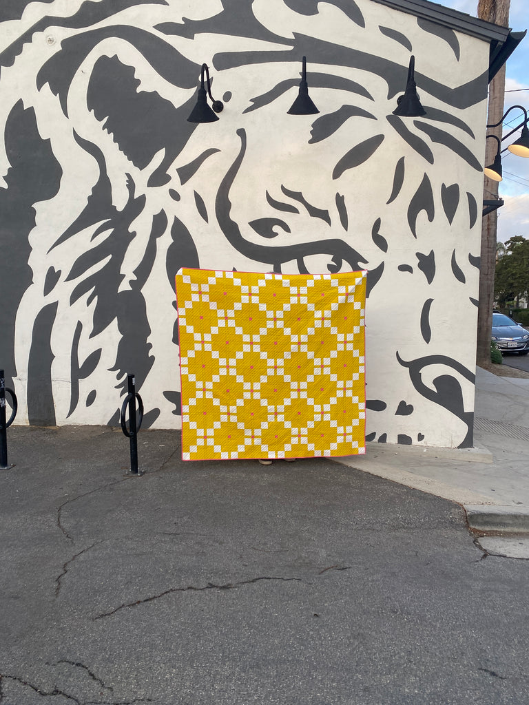 Yellow Harken Quilt in front of wall