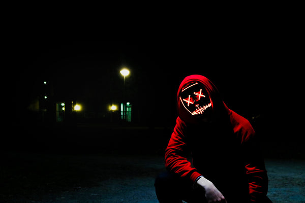 Homme masqué portant un hoodie rouge