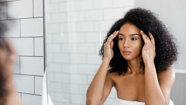 woman checking skin in mirror