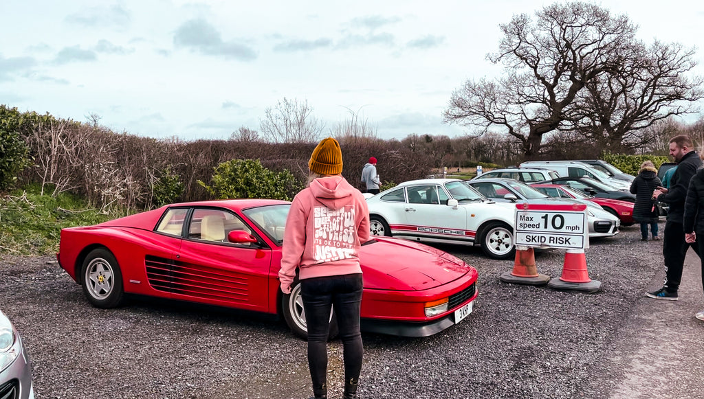Takona hoodie in front of a Ferrari Testarossa