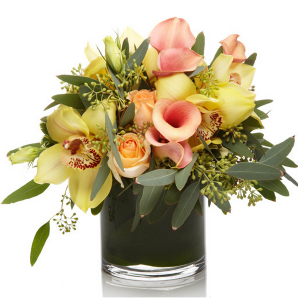 Glow by H.Bloom is a pastel yellow and peach floral design with orchids and calla lilies.