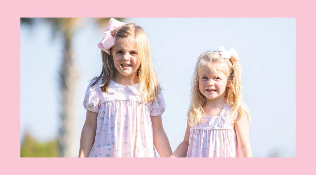 2 little girls holding hands outside in Easter Dresses