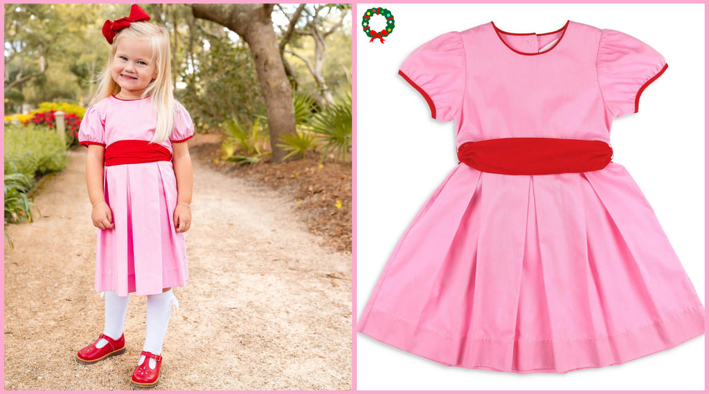 little girl in pink dress with a red bow in her hair and tied on her dress - Tips for An Easy Family Christmas Photo Shoot