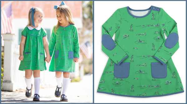 2 girls holding hands wearing green mallard dresses