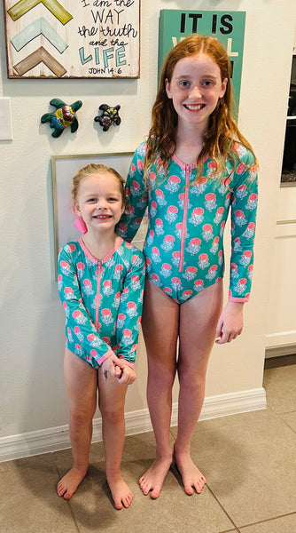 2 little girls smiling in shrimp and grits kids bathing suits