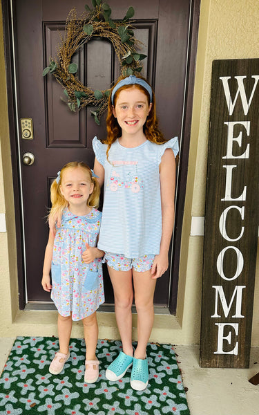 2 little girls smiling standing in front of a door
