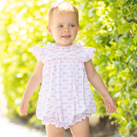 toddler in white bubble romper with pink bows for girls