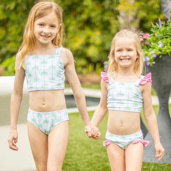 2 little girls smiling at the camera in their bathing suits