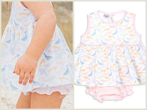 little girl on the beach in a summer print with whales