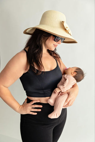 woman holding a newborn baby while wearing a sunhat and a black Davin & Adley Amelia Cami