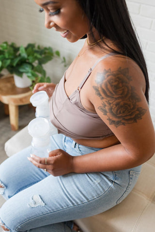 woman using a breast pump and modeling a Davin & Adley pumping bra