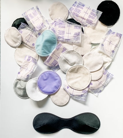 A pile of reusable and disposable nursing pads next to a one piece nursing pad.