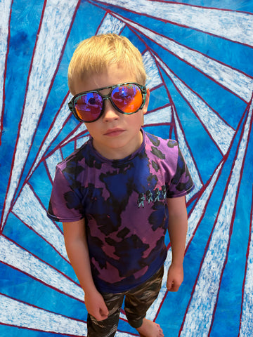 a cool kid staring into your soul, in front of a red, blue, and white spiral.