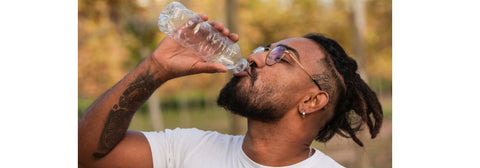 Man with healed tattoo drinking water