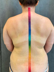 Ink Defense Proteam artist Em Whiteseth rainbow pride spine tattoo