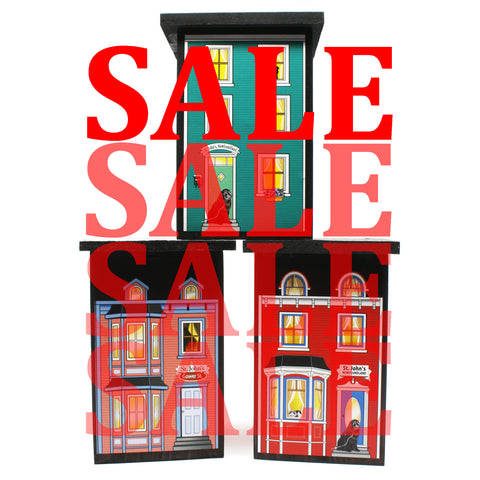 three wooden houses with SALE text in front of them