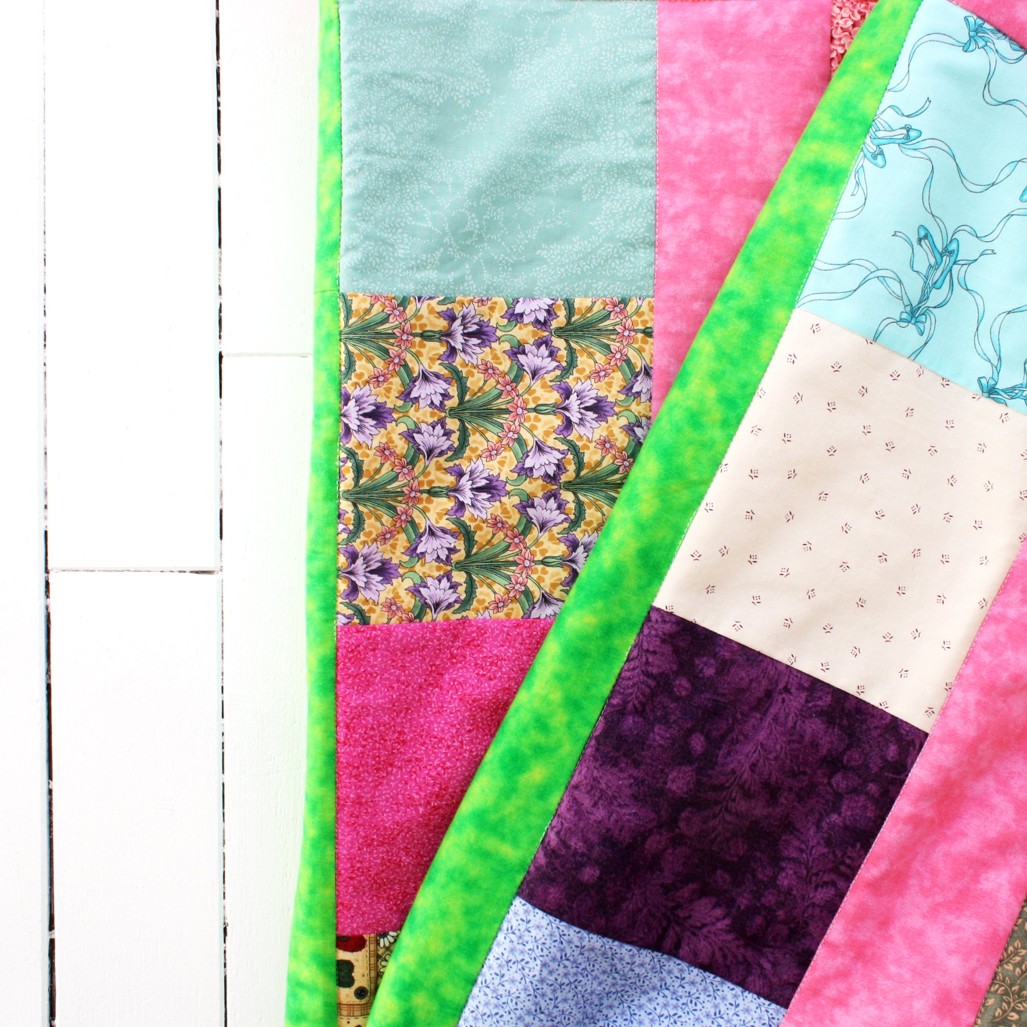 snuggle quilt with colorful patches and bright green border